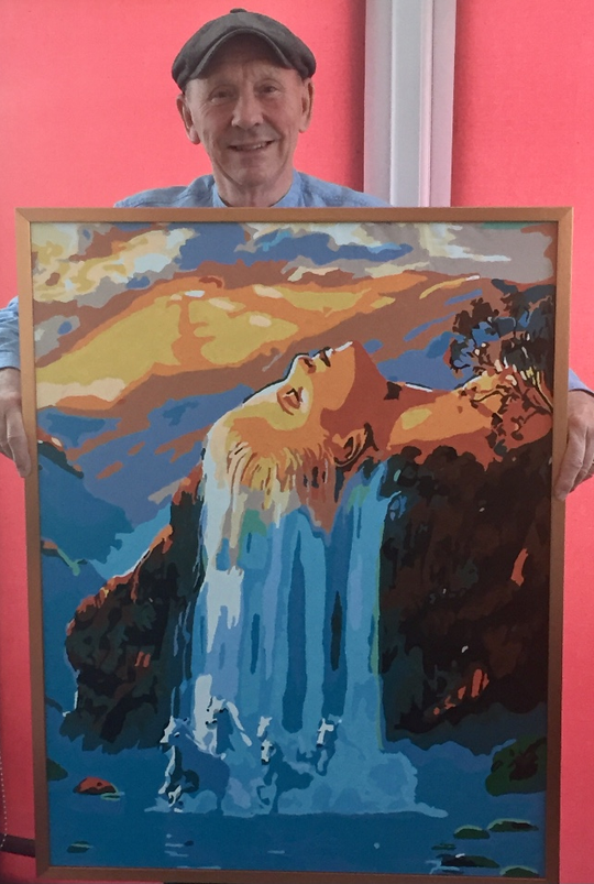 Roberto mostrando su pintura por números terminada